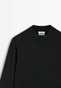 Maglione nero con scollatura rotonda, polsini e orlo a coste, realizzato in un tessuto morbido e testurizzato. Etichetta visibile al collo.