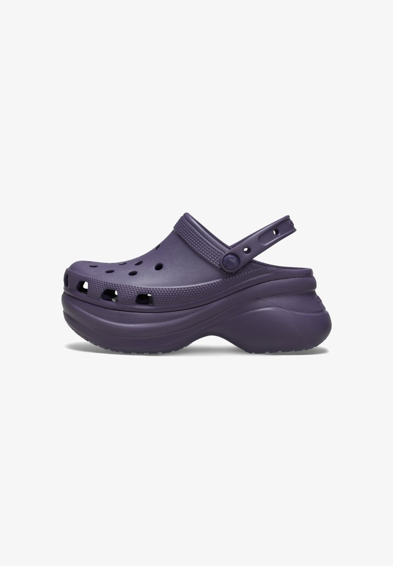Sabot violet à enfiler avec des trous de ventilation, une bride de talon réglable et une semelle plateforme épaisse, conçu pour le confort et un usage casual.