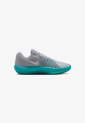 Zapatilla deportiva gris de corte bajo con suela y cordones en color teal, con una parte superior de malla texturizada y un logo Nike en el lateral.