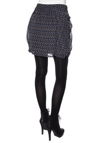 Mini falda de rayas azul marino con diseño de volantes, superposición transparente, cintura elástica, y combinada con medias negras y botines de tacón alto.