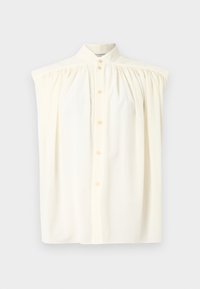 Krémová bezrukávová blúzka s vysokým golierom, zapínaním na gombíky a nariasením na pleciach. Hladký textilný povrch.