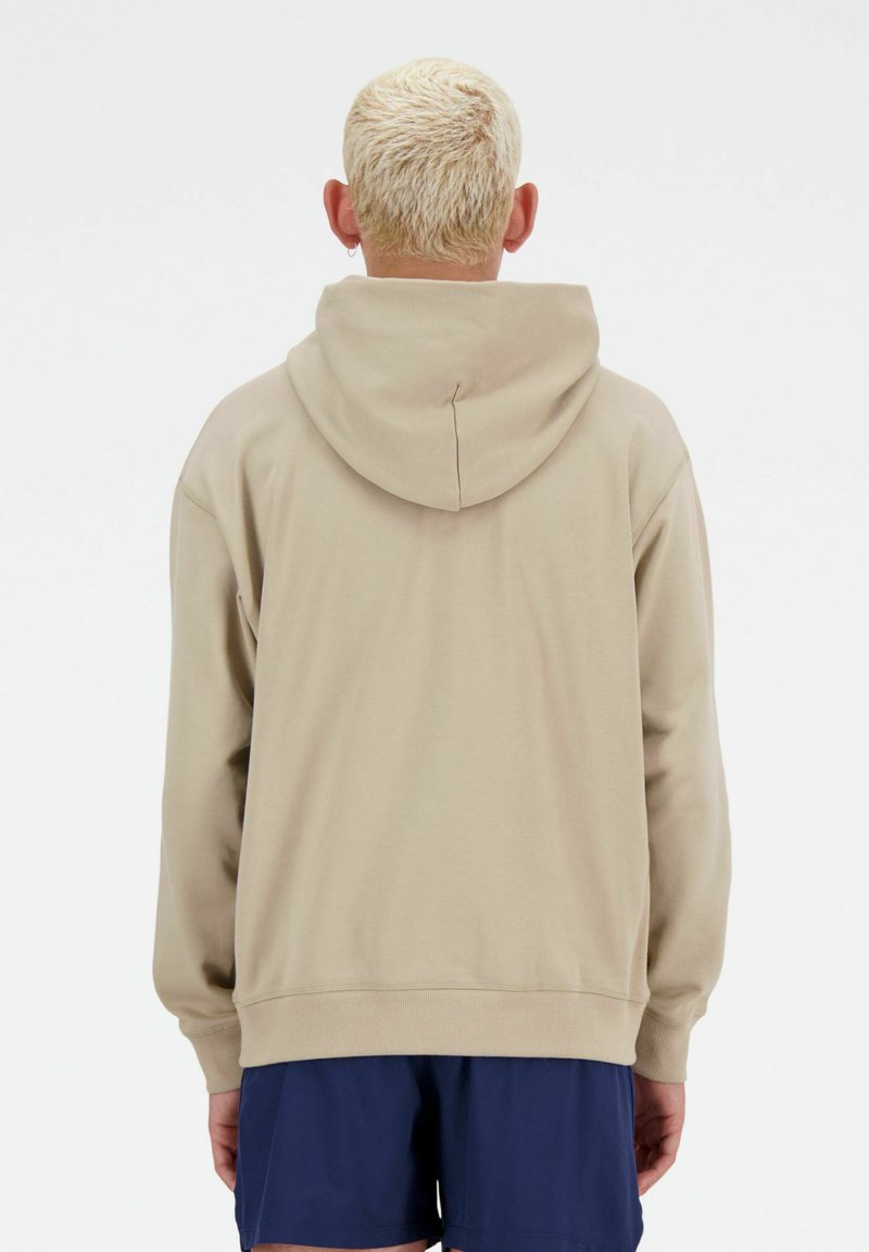 Sweatshirt beige à capuche avec une coupe décontractée, des manches longues et des poignets côtelés, vu de dos. Texture lisse, sans motifs visibles.