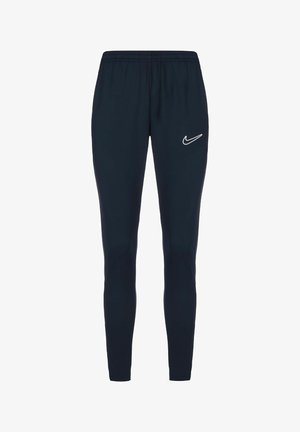 Navyblaue Sporthosen mit einem dehnbaren Bund und tapered Fit. Mit einem weißen Nike-Logo auf dem linken Oberschenkel. Glatte Stoffstruktur.