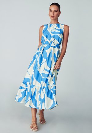 Maksimekko, jossa on sinivalkoinen abstrakti kuvio, hihaton muotoilu, joustava vyötärö ja röyhelöhelma. Materiaali vaikuttaa kevyeltä.