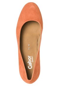 Ballerines en daim couleur saumon, à bout rond, dotées d'une semelle intérieure rembourrée et d'un logo subtil à l'intérieur. Texture lisse.