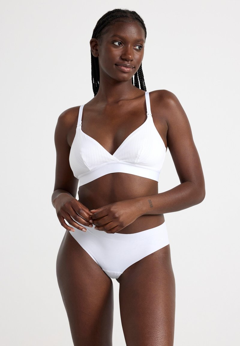 White bra and matching bikini briefs with a smooth texture and minimalistic design. The bra features thin adjustable straps and a seamless finish.