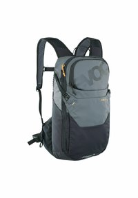 Sac à dos gris et noir avec plusieurs compartiments, poches zippées, bretelles rembourrées et un logo. Caractéristiques : tissu durable et design élégant.