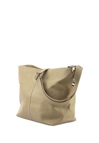 Beige leren tote bag met een zachte textuur, een gebogen vorm en een ritsluiting. Voorzien van een klein charm met de Italiaanse vlag aan de strap.