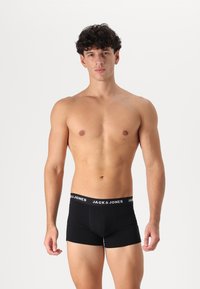 Schwarze Baumwoll-Boxershorts mit breitem elastischem Bund und dem weißen "JACK & JONES"-Logo sowie einer taillierten Passform. Glatte Textur und kurze Beinlänge.
