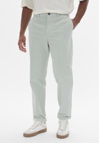 Pantalons droits vert clair en tissu de coton doux. Dot�és d'une fermeture à bouton et de poches avant, avec des ourlets retroussés.