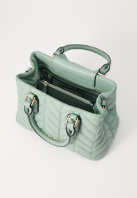 Kvált zöld bőr kézitáska, melynek felső fogantyúi, arany hardware részletei és több belső rekesze van a rendezett tároláshoz.