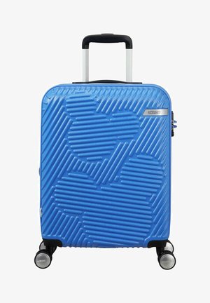 Valise rigide bleue avec un design texturé en relief, poignée noire, quincaillerie argentée et quatre roues pour une mobilité aisée.