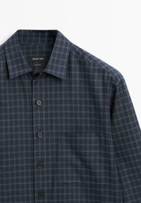 Marineblauw geruit overhemd van katoen met een button-down kraag, zwarte knopen en een borstzak. Heeft een ruitpatroon met subtiele accenten.