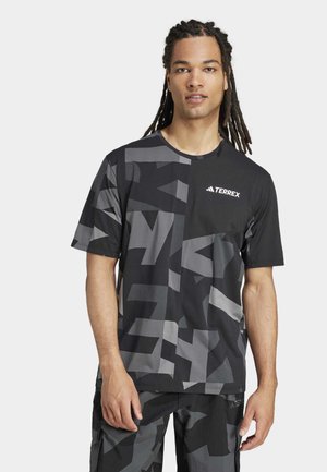 Černé tričko s krátkým rukávem s vzorem, které obsahuje šedé abstraktní designy. Materiál vypadá lehce, má kulatý výstřih a na hrudi je logo Terrex.