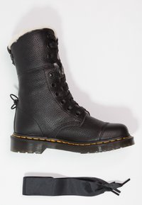 Botte de combat en cuir noir avec une surface texturée, une doublure chaude, des coutures jaunes, un bout poli et un ruban en satin noir inclus.