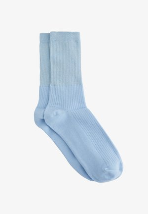 Calzini azzurri chiaro con texture a costine, caratterizzati da un design uniforme e un risvolto blu leggermente più scuro. Realizzati in tessuto morbido ed elastico.