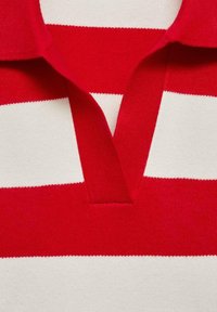 Chemise tricotée à rayures horizontales rouges et blanches avec un col plié et un décolleté en V.