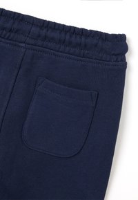 Pantaloni jogger in cotone blu navy con vita elastica, dotati di una tasca posteriore singola e una texture liscia. Design semplice, senza motivi.