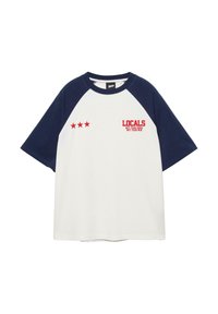 T-shirt raglan blanc à manches courtes avec manches et col bleu marine, design rouge à trois étoiles, et texte "LOCALS NOT YOUR HOME NOT YOUR WIN" sur la poitrine.