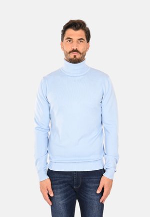 Maglione a collo alto di colore azzurro chiaro, con una texture a costine, dotato di maniche lunghe e un design aderente. Abbinato a jeans scuri.