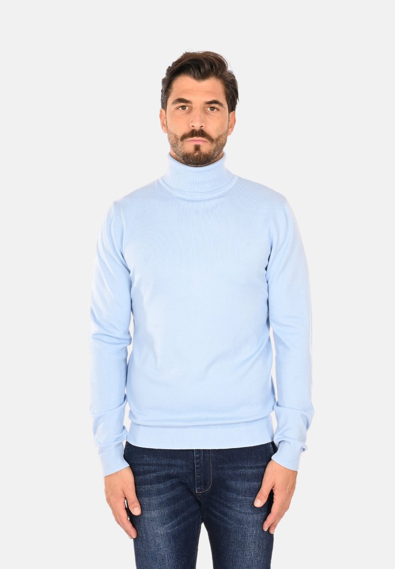 Maglione a collo alto di colore azzurro chiaro, con una texture a costine, dotato di maniche lunghe e un design aderente. Abbinato a jeans scuri.