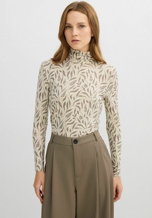 Top de manga larga con cuello alto, con fondo beige y patrones marrones de hojas botánicas. Tejido suave con silueta ajustada.