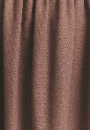 Braun gewebter Stoff mit strukturierter Oberfläche, der sanfte Falten und ein leichtes, luftiges Erscheinungsbild zeigt. Geeignet für verschiedene Textilanwendungen.