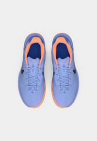 Svetlo modri športni copati z teksturiranim zgornjim delom, oranžnimi poudarki in črnim logotipom Swoosh, z zavezovanjem na vezalke in oblazinjeno podplatom.