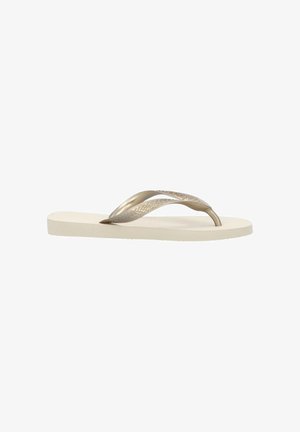 Beige flip-flop sandal med teksturerede metalliske gyldne stropper og flad sål, vist i sideprofil på hvid baggrund.