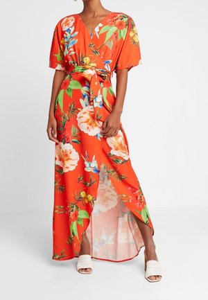 Robe longue fleurie, tissu orange avec de grands motifs floraux blancs et colorés, manches courtes, décolleté en V profond, fente latérale, nouée à la taille.