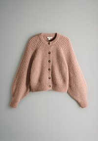 Cardigan roz pal, tricotat gros, cu decolteu rotund, mâneci lungi bufante și șapte nasturi maro pe partea din față, așezat plat pe o suprafață gri.