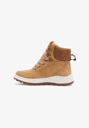 Tan ruskindsankelstøvle med brune læderdetaljer, snørebåndsdesign, polstret krave og hvid gummimellemsål med struktureret brun ydersål.