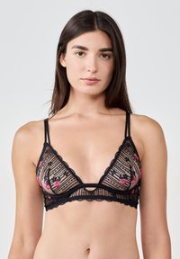 Bralette en dentelle noire avec broderie florale en rose et vert. Forme triangulaire, bords festonnés, bretelles réglables et texture transparente.