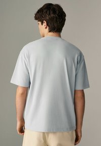 Lysblå bomulds T-shirt med korte ærmer, rund hals og en afslappet pasform. Glat tekstur, ingen synlige mønstre eller detaljer.