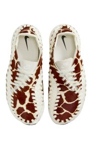 Vita sneakers med ett mönster av nötkötts läder i brunt, med ett vävt mönster, snörning och en diskret Nike-logotyp på tungan.