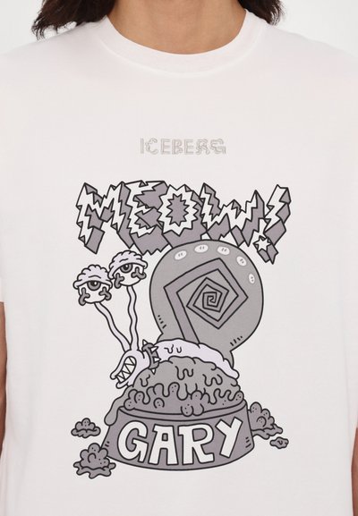 Hvid bomulds-T-shirt med et grafisk print af en tegneserie snegl og teksten "MEOW" og "GARY" i sort og grå, med et spiral design.