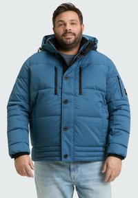 Modra napihljena jakna z odstranljivo kapuco, gumbom spredaj in dvema zadrgo zapirajočima žepoma na prsih; ima teksturiran, lepenjakov vzorec.