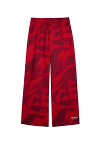 Rode wijde broek van stof met een geometrisch patroon. Elastische tailleband met een klein achterzakje. Geaccentueerd met witte tekst.