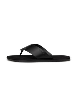 Black flat flip-flop sandal with wide strap and toe post, featuring subtle embossed brand name on the side of the strap.