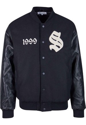 Sort varsityjakke med uldkrop og læderærmer. Har hvide broderede detaljer "S" og "1999". Trykknaplukning foran.