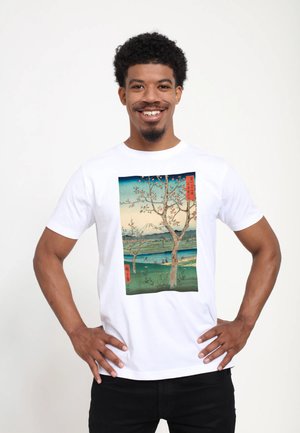 Bílá bavlněná tričko s barevným potiskem krajiny, na kterém jsou stromy, hory a voda. Design má japonský umělecký styl s textovými akcenty.