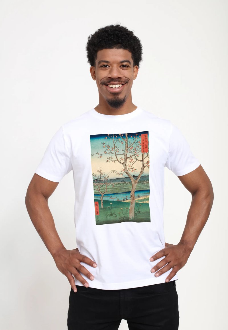 Bílá bavlněná tričko s barevným potiskem krajiny, na kterém jsou stromy, hory a voda. Design má japonský umělecký styl s textovými akcenty.