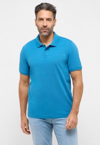 Modrá polo košile vyrobená z bavlny s texturovaným povrchem. Disponuje třemi knoflíky a krátkými rukávy, doplněná výšivkou loga.
