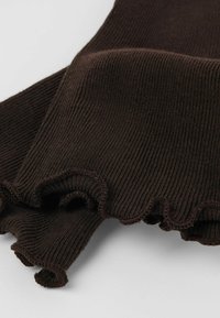 Brązowy materiał w prążki z falistym wykończeniem. Miękka tekstura, złożony i warstwowy wygląd, podkreślający elastyczność materiału.