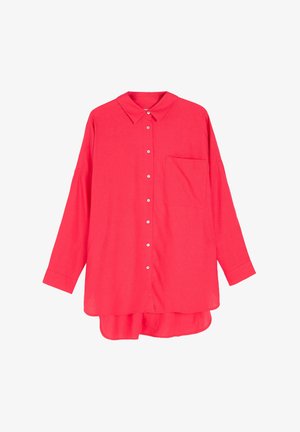 Jasnoróżowa bluzka z długim rękawem i kołnierzykiem, z zapięciem na guziki z przodu, pojedynczą kieszenią na piersi oraz nieco dłuższym tylnym dołem. Wykonana z lekkiego materiału.