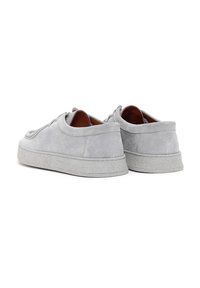 Zapatillas de ante gris con diseño de caña baja, puntera redonda y suela de goma. Presentan cordones tonales y una superficie texturizada. Acentos de costura doble.