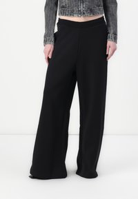 Pantaloni neri a gamba larga con vita elastica, realizzati in un tessuto liscio, presentano un design pulito e un taglio a lunghezza intera.