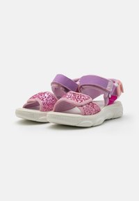 Glitrende rosa og lilla sandaler med justerbare stropper, polstret såle og hvit gummisåle med et bølgete mønster.