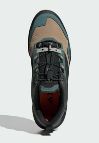 Buty outdoorowe z czarną i brązową siateczką, akcentami w kolorze turkusowym, teksturowanymi materiałami oraz bezpiecznym systemem sznurowania z uchwytem.