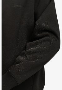 Black sweatshirt featuring a textured material with water droplets on the sleeve. Includes "Element Skateboard Co" logo in a subtle print.